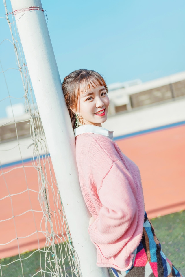 二月操场粉色毛衣美女抵御早春寒气阳光写真