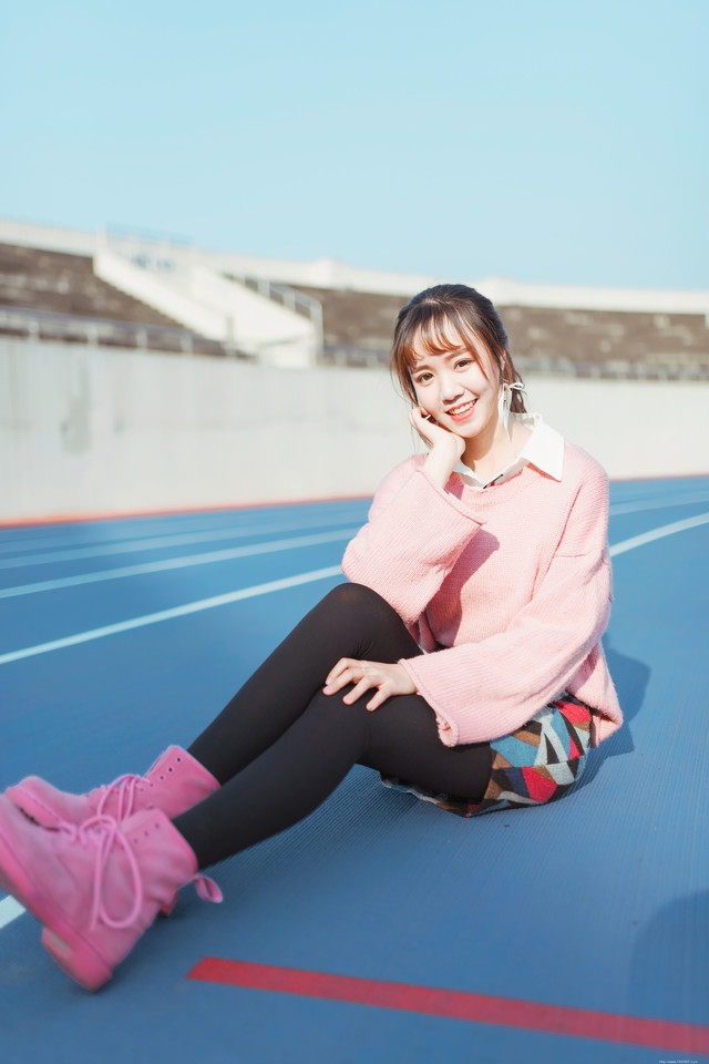 二月操场粉色毛衣美女抵御早春寒气阳光写真