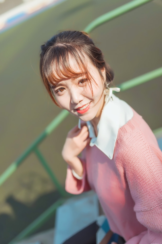 二月操场粉色毛衣美女抵御早春寒气阳光写真