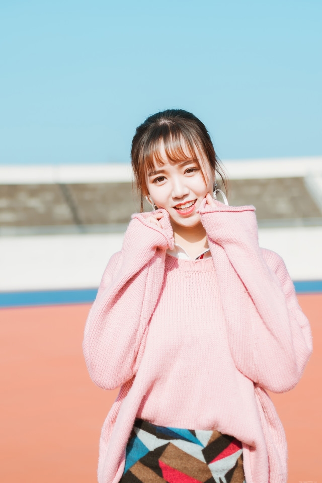二月操场粉色毛衣美女抵御早春寒气阳光写真