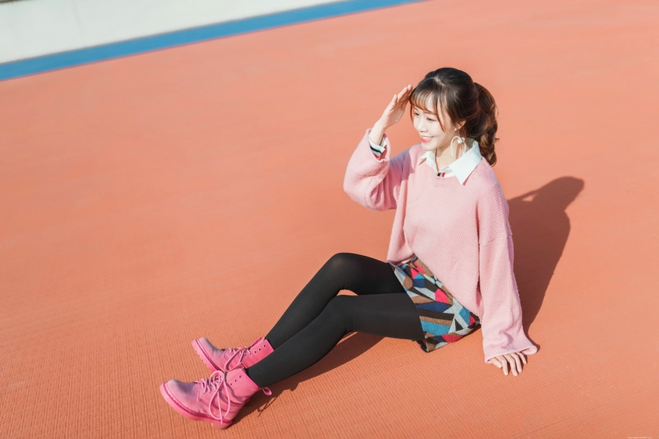 二月操场粉色毛衣美女抵御早春寒气阳光写真