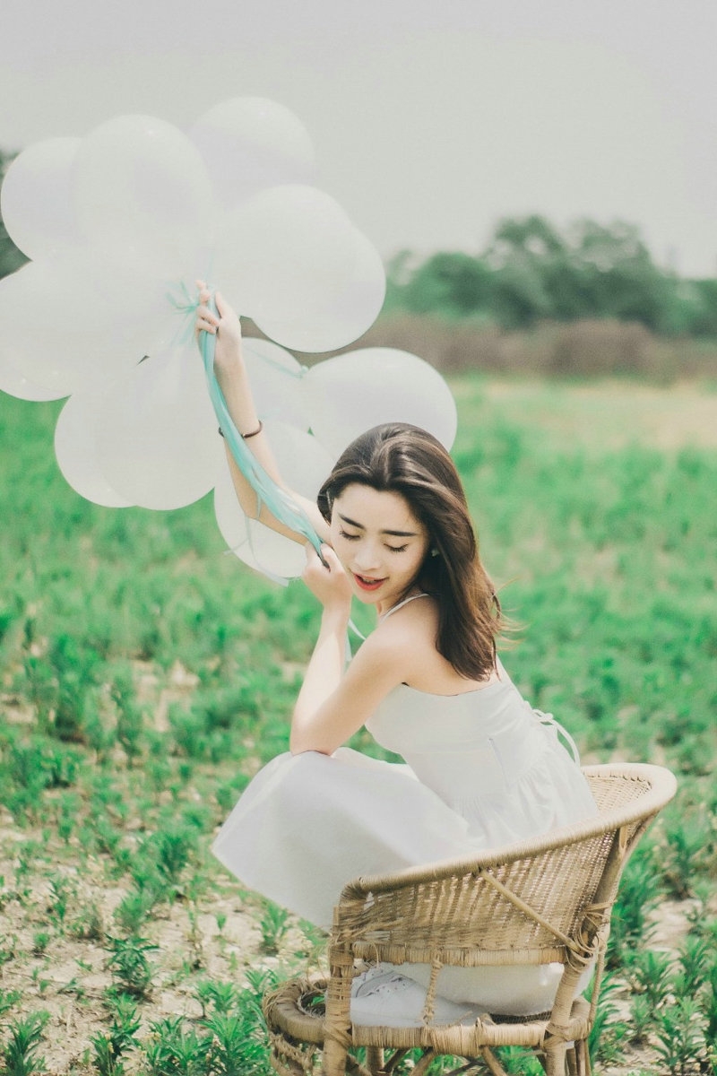 气质美女白色吊带礼裙荒野上放飞气球