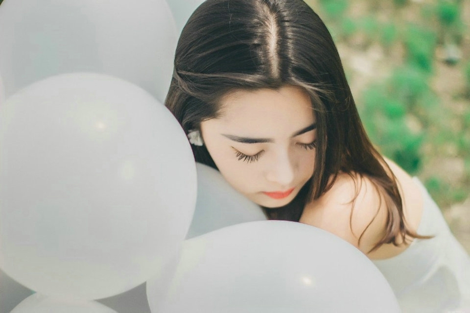 气质美女白色吊带礼裙荒野上放飞气球