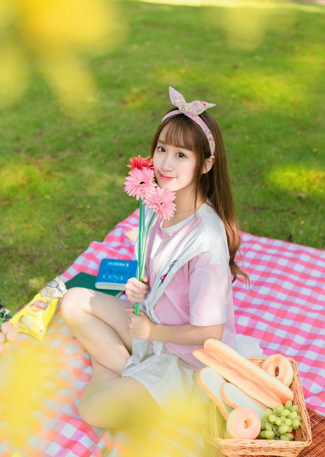 阳光下野餐少女躺在餐布上看向天空