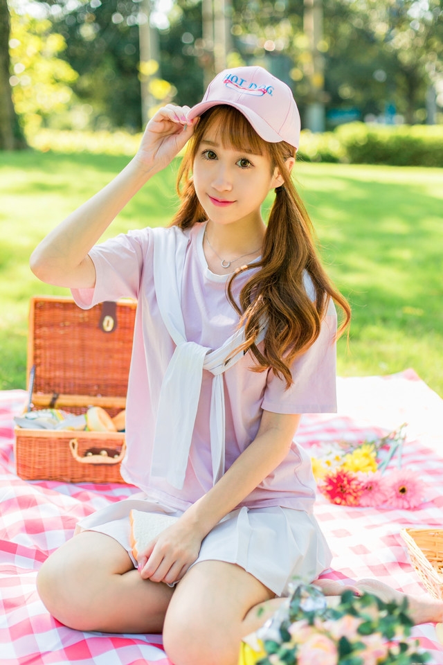 阳光下野餐少女躺在餐布上看向天空