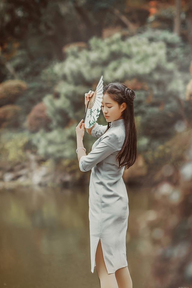 庭院内放风筝的旗袍美女展东方美池边戏水