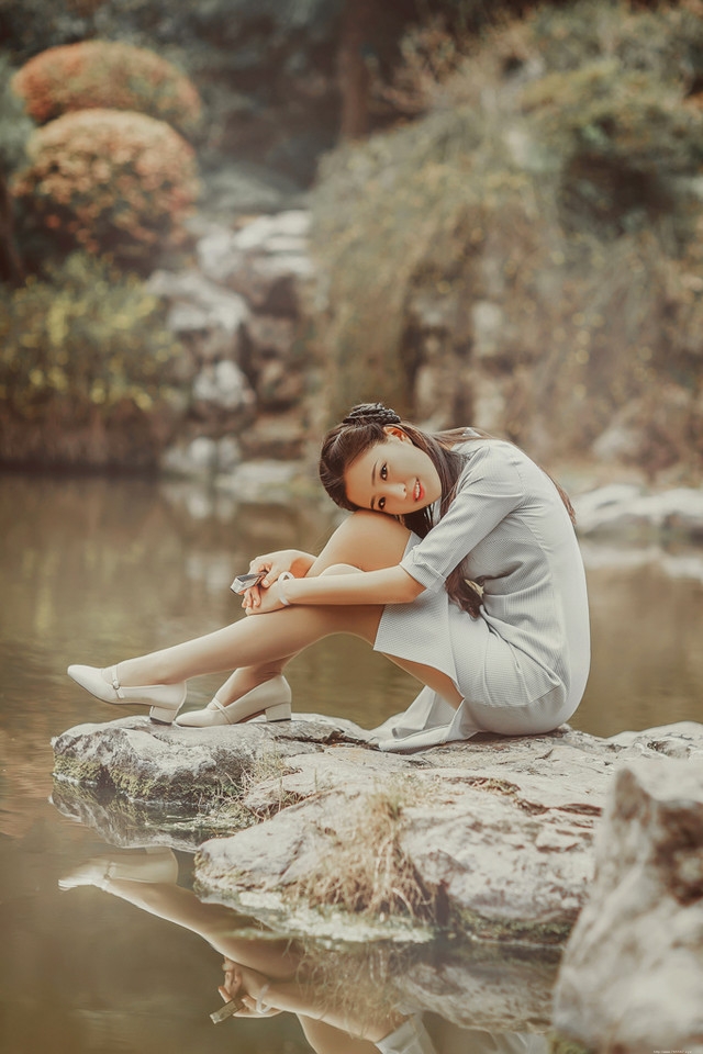 庭院内放风筝的旗袍美女展东方美池边戏水