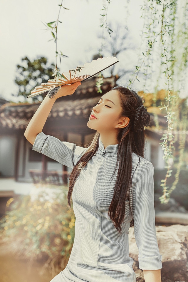 庭院内放风筝的旗袍美女展东方美池边戏水