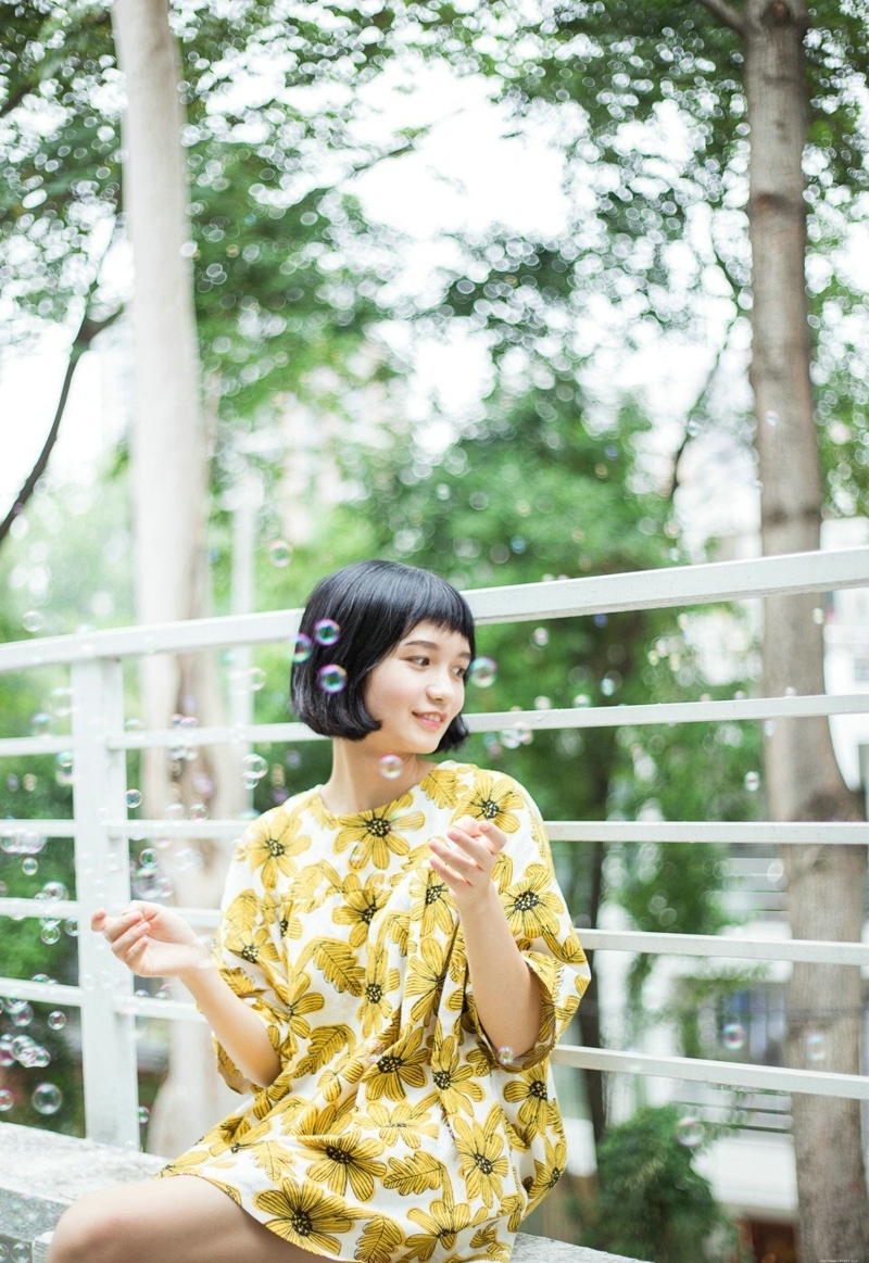 阳光下的短发向日葵妹子与泡泡玩耍