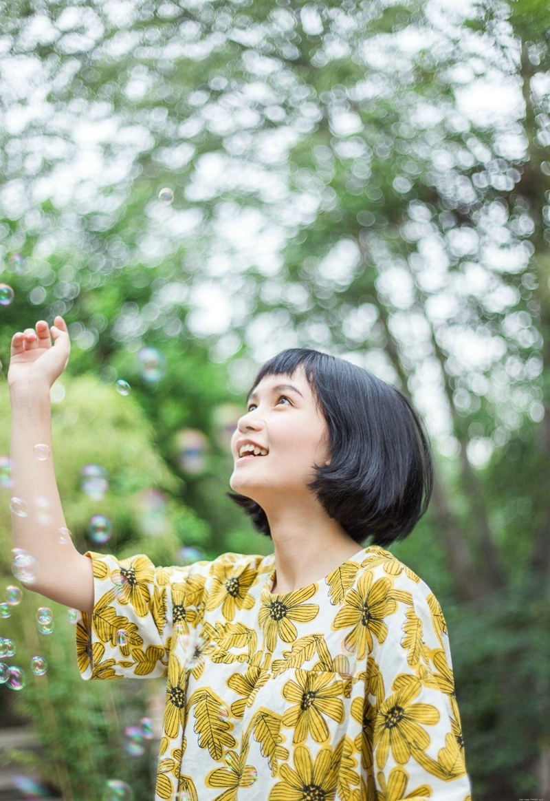 阳光下的短发向日葵妹子与泡泡玩耍