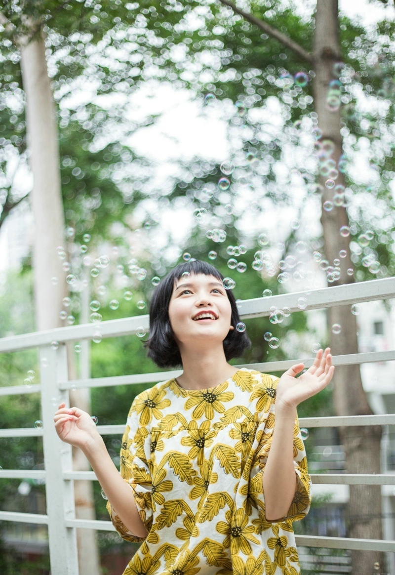 阳光下的短发向日葵妹子与泡泡玩耍