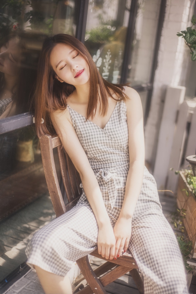 阳台美女深V连体裤享受日光浴闭眼舒适