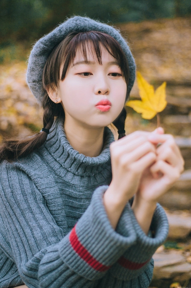 贝雷帽麻花辫美女落叶下安静看书露牙套浅笑