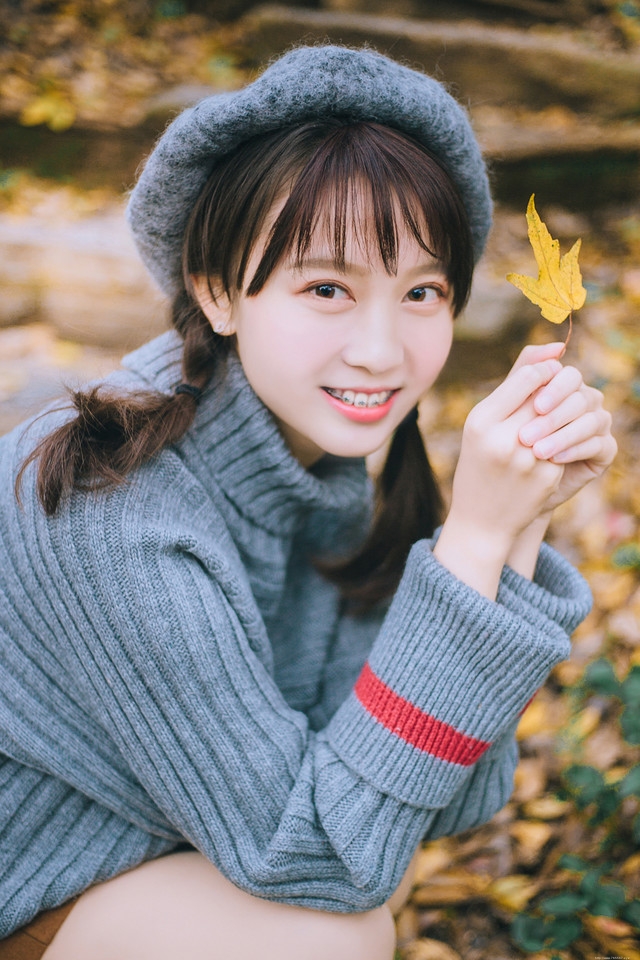 贝雷帽麻花辫美女落叶下安静看书露牙套浅笑