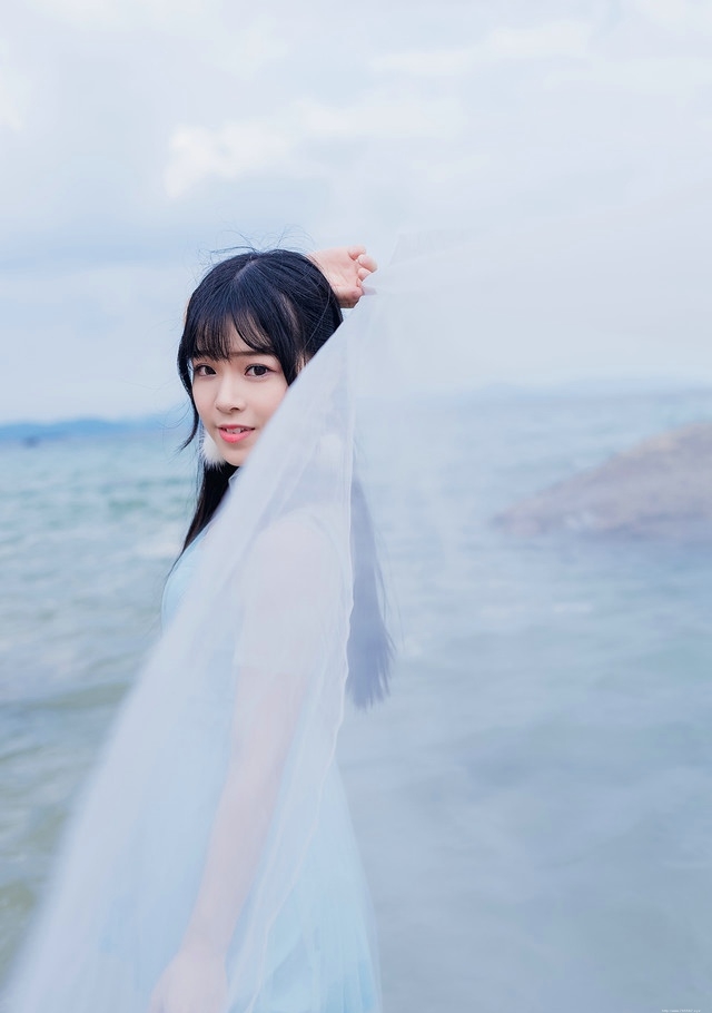 蓝色天空下透视白纱裙美女海水中湿身戏水