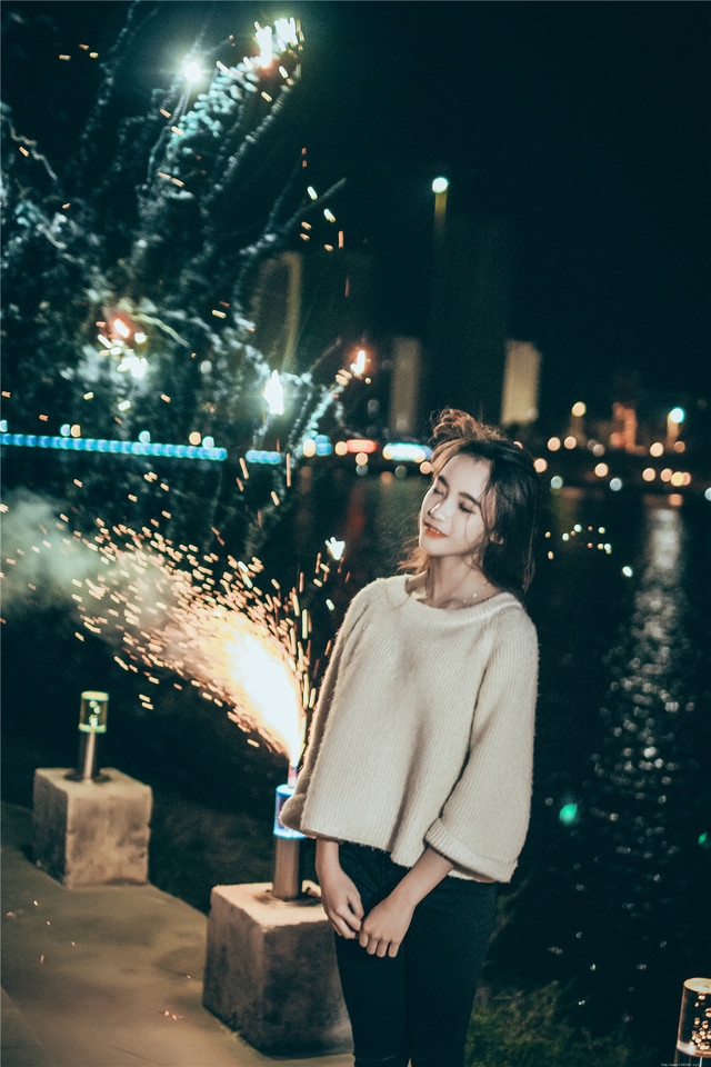 夜晚长发美女街头放烟花笑容无比愉悦