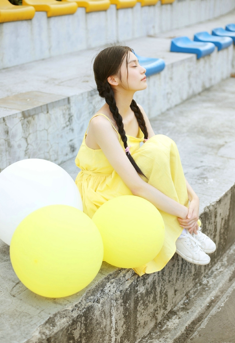 草地上的黄色靓丽连衣裙麻花辫姑娘美丽动人