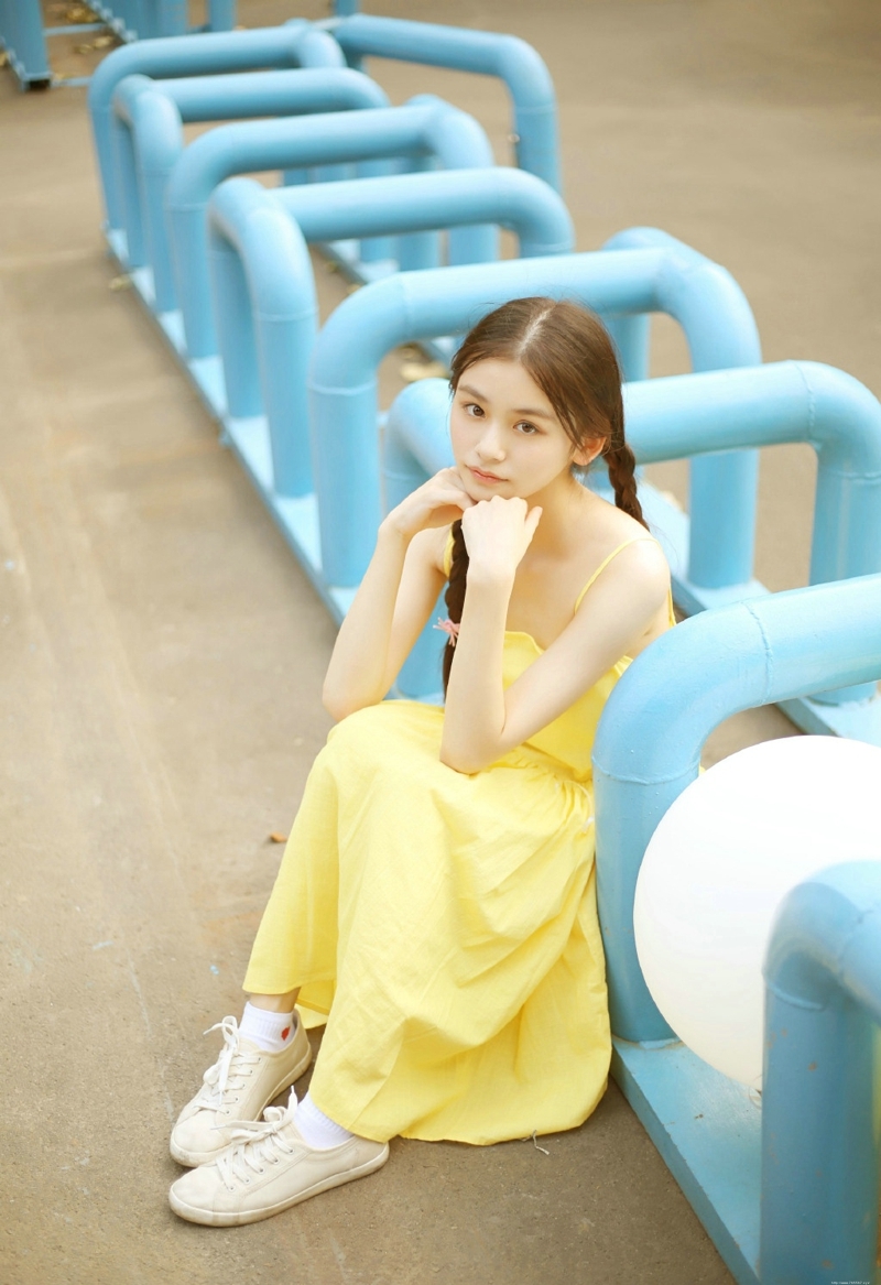 草地上的黄色靓丽连衣裙麻花辫姑娘美丽动人