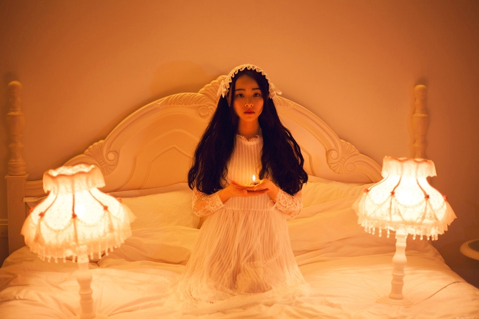 床上的失恋女孩手捧烛光情绪崩溃