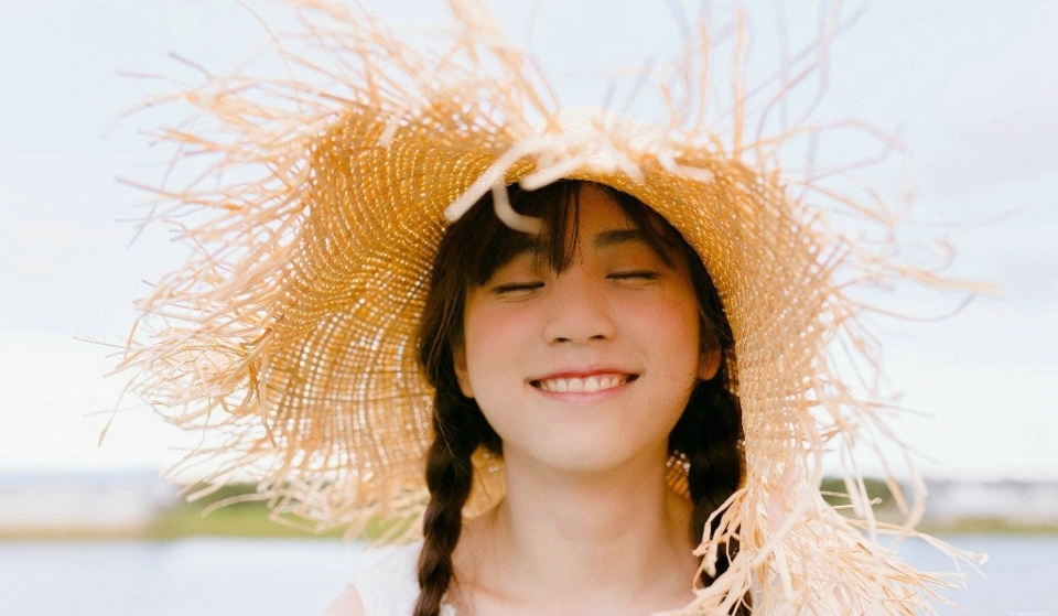 阳光明媚天空下的草帽氧气少女白皙肌肤