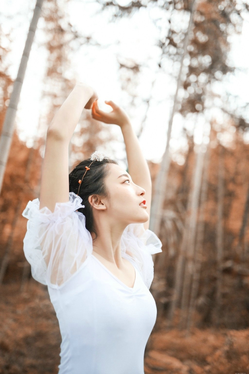 深秋落叶堆中的白纱裙气质盘发美女