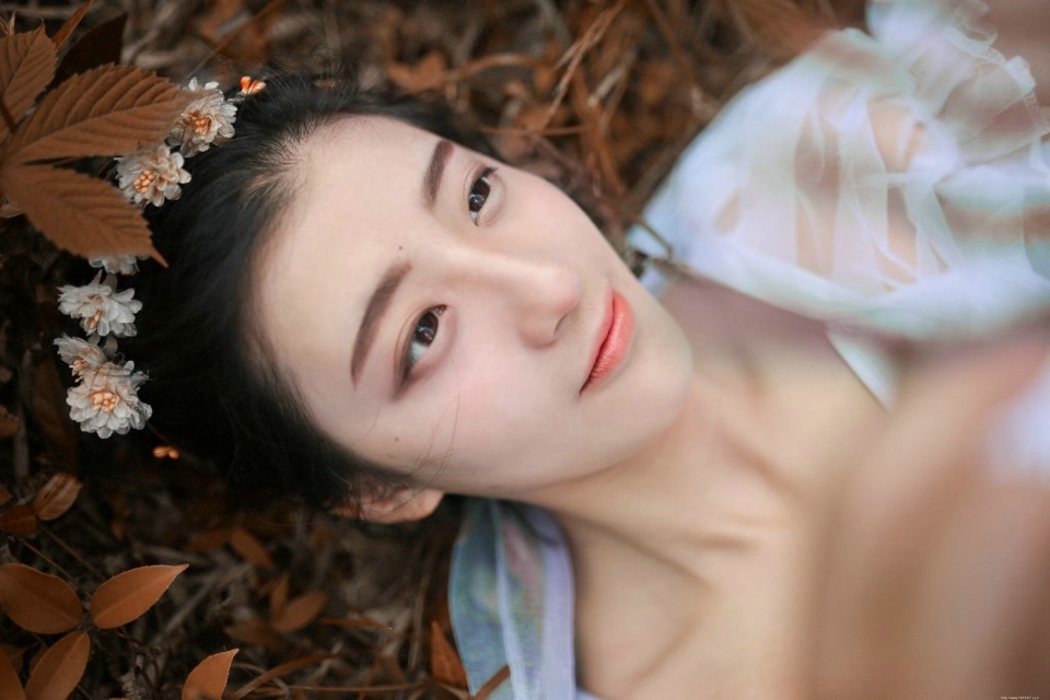 深秋落叶堆中的白纱裙气质盘发美女