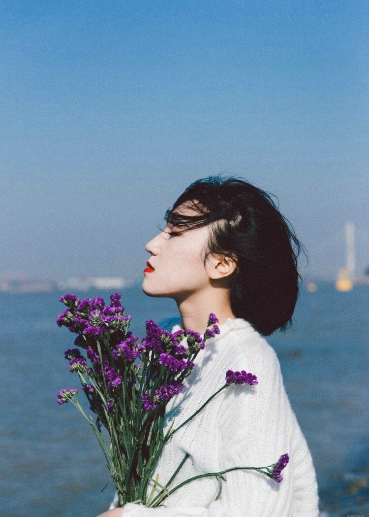 海岸边的红唇花束美女秀发飘扬