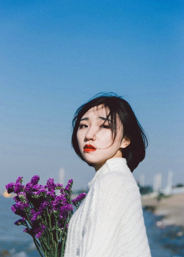 海岸边的红唇花束美女秀发飘扬