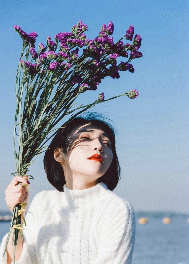海岸边的红唇花束美女秀发飘扬