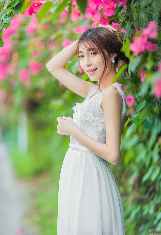 公园内的花恋美女蕾丝裙梨涡甜笑美艳十足