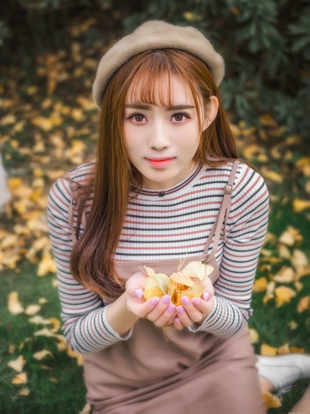 草坪上的秋天落叶美女俏皮纯真展冬日气氛