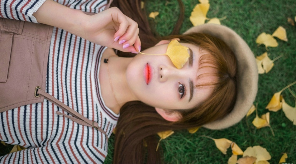 草坪上的秋天落叶美女俏皮纯真展冬日气氛