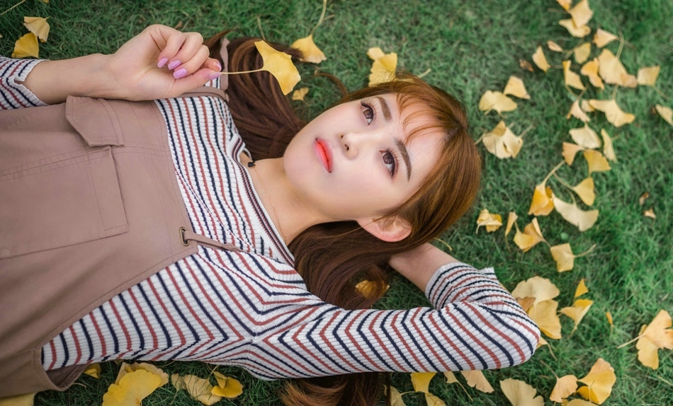 草坪上的秋天落叶美女俏皮纯真展冬日气氛