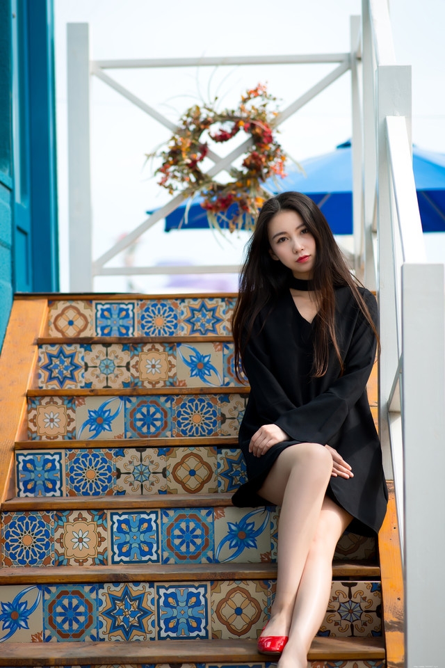 夏日清风长发美女坐在台阶上展修长美腿