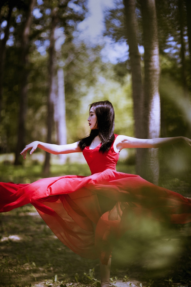 深林内如痴如醉跳舞的红裙美女展示好身材