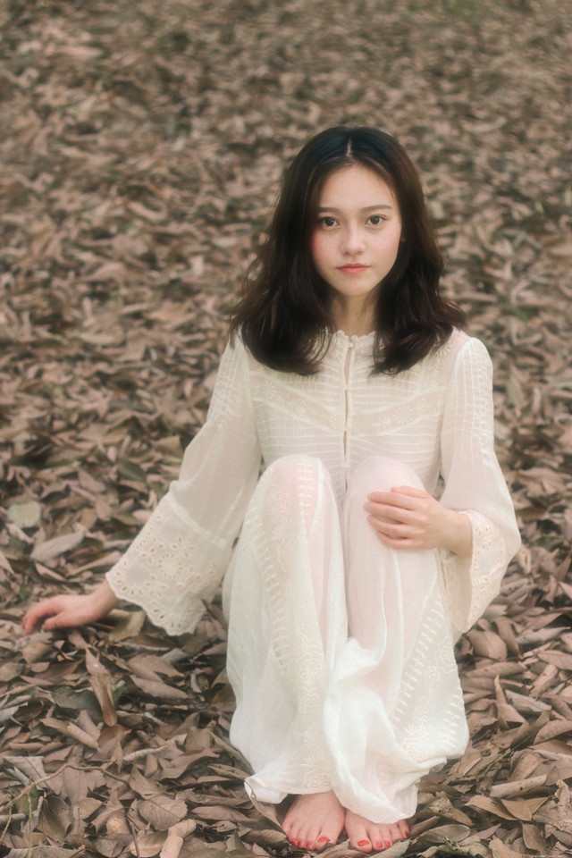 头戴花环的白色长裙美女赤脚行走在深林