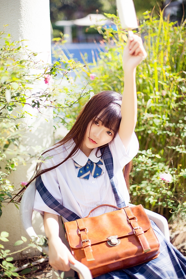 花一般的长发妹子坐在庭院内吃着棒冰享受阳光