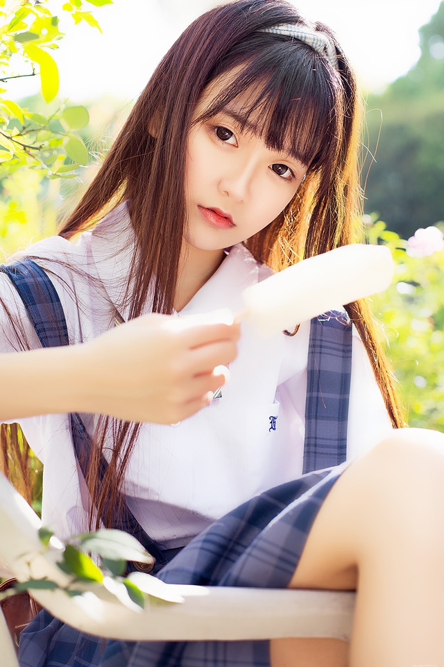 花一般的长发妹子坐在庭院内吃着棒冰享受阳光