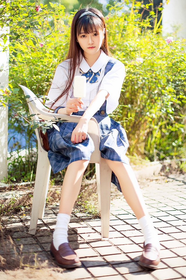 花一般的长发妹子坐在庭院内吃着棒冰享受阳光