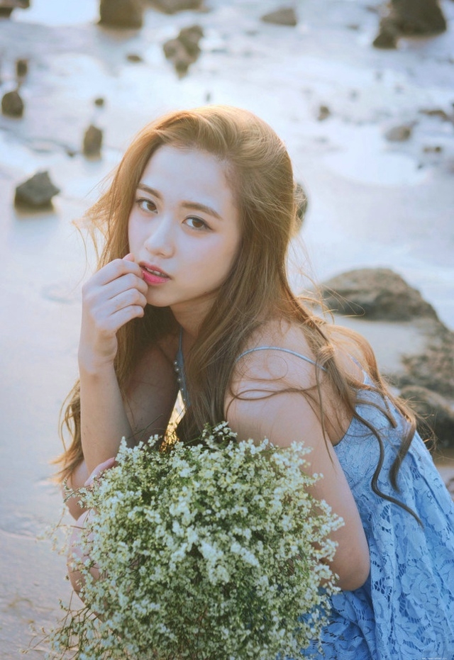 逆光下的海滩美女蓝色蕾丝连衣裙捧花清新