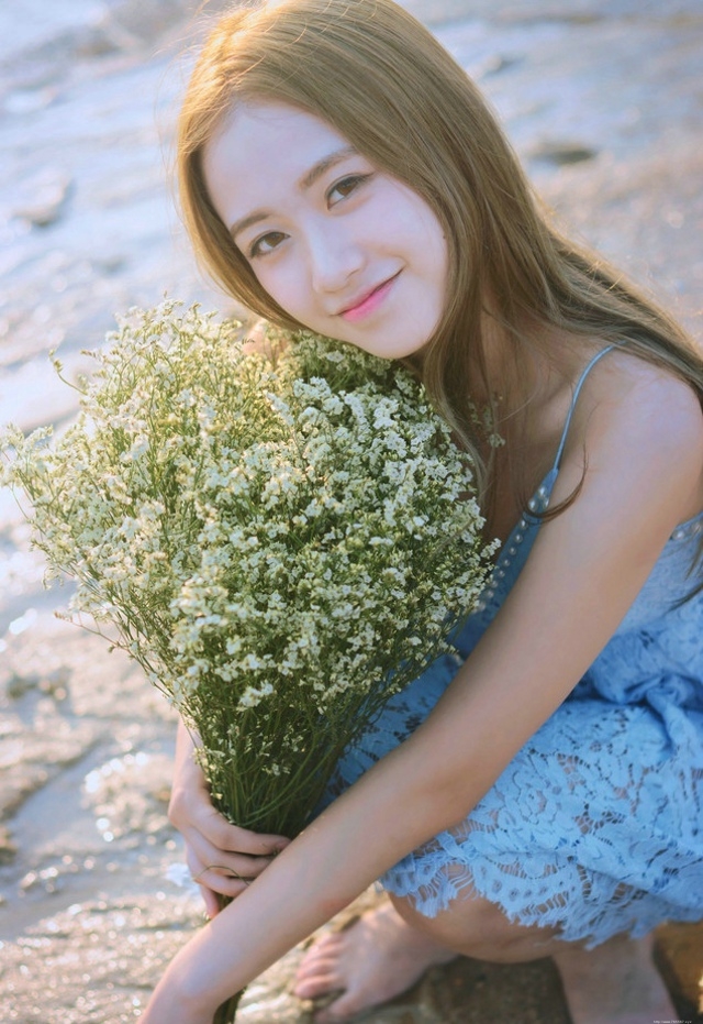 逆光下的海滩美女蓝色蕾丝连衣裙捧花清新