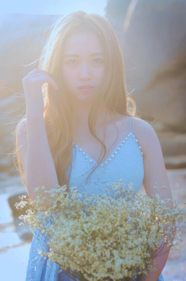 逆光下的海滩美女蓝色蕾丝连衣裙捧花清新