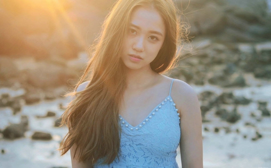 逆光下的海滩美女蓝色蕾丝连衣裙捧花清新