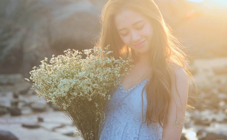 逆光下的海滩美女蓝色蕾丝连衣裙捧花清新