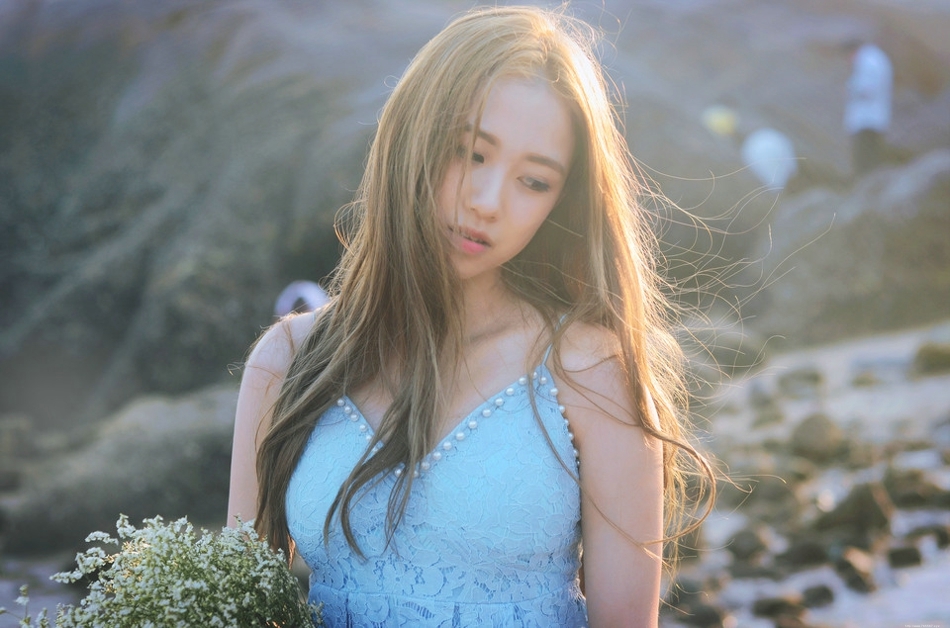 逆光下的海滩美女蓝色蕾丝连衣裙捧花清新