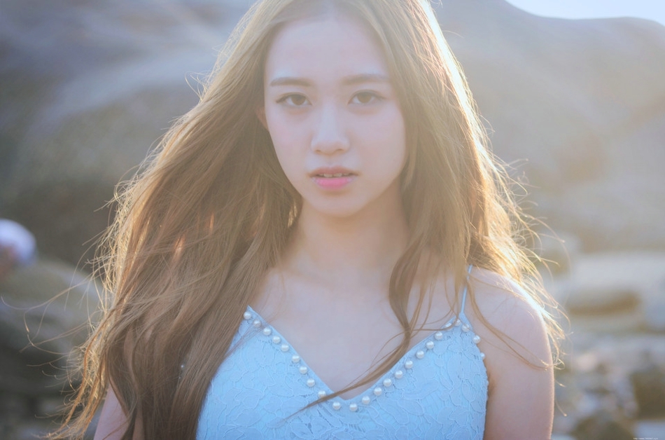 逆光下的海滩美女蓝色蕾丝连衣裙捧花清新