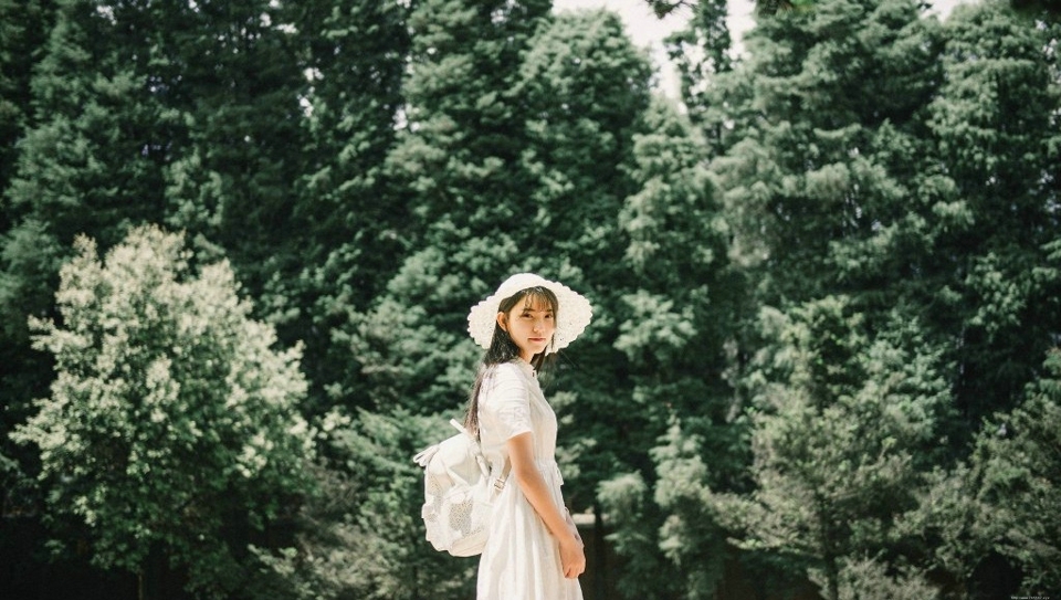 森林公园内的白裙草帽背包少女清爽怡人