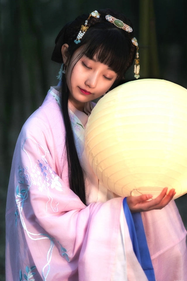 竹林内提灯笼的古装美女吹箫清丽脱俗