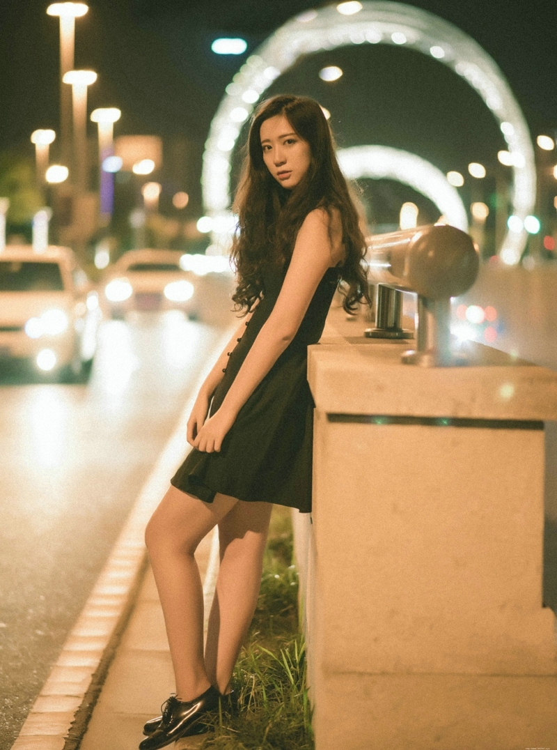 夜晚街头上的吊带裙长发气质美女