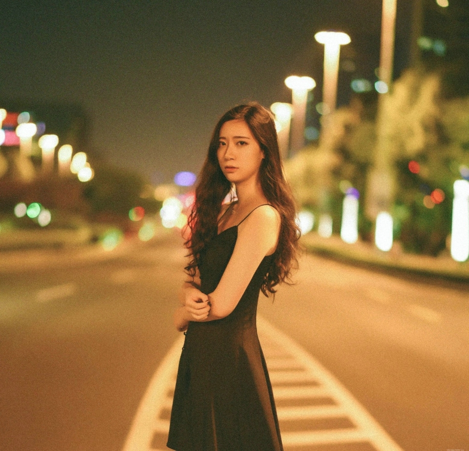 夜晚街头上的吊带裙长发气质美女